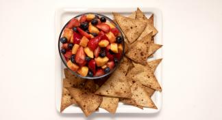 plate with tortilla chips and bowl of salsa