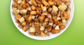 Cubed and roasted Irish and sweet potatoes on a white serving platter.